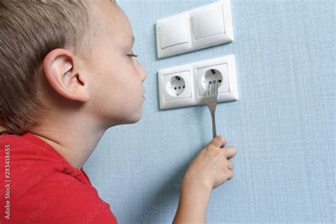 boy sticking fork into electrical box|putting fork in electrical outlet.